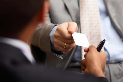 A picture of a man handing a business card